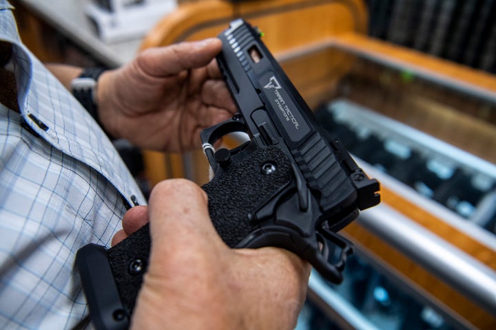 FILE - A customer checks out a hand gun that is for sale and on display at SP firearms on June 23, 2022, in Hempstead, New York. A landmark Supreme Court decision on the Second Amendment is dismantling gun law across the country, dividing judges and sowing confusion over what firearm restrictions can remain on the books. Experts say the high court’s ruling that outlined a new test for evaluating gun laws left open many questions, resulting in an increasing number of conflicting decisions as lower court judges struggle to figure out how to apply it. (AP Photo/Brittainy Newman, File)