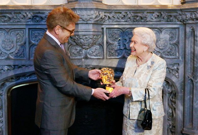 Queen Elizabeth II receives an honorary Bafta from actor and director Kenneth Branagh in recognition of a lifetime's support of British film and television at Windsor Castle in Windsor on April 4, 2013. 