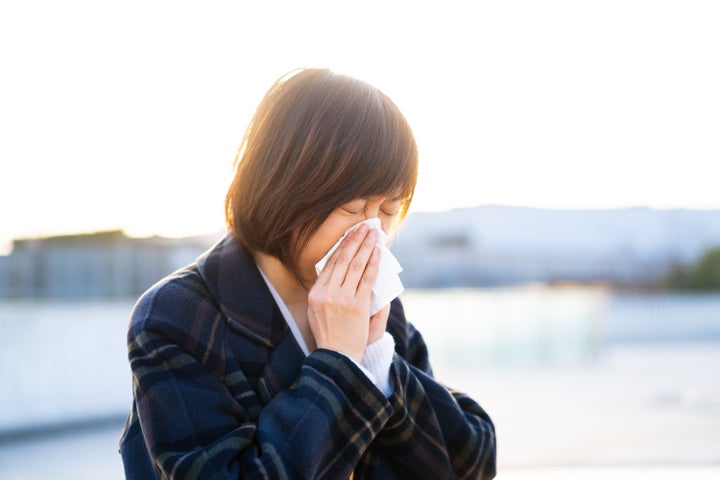 asian female blowing his nose