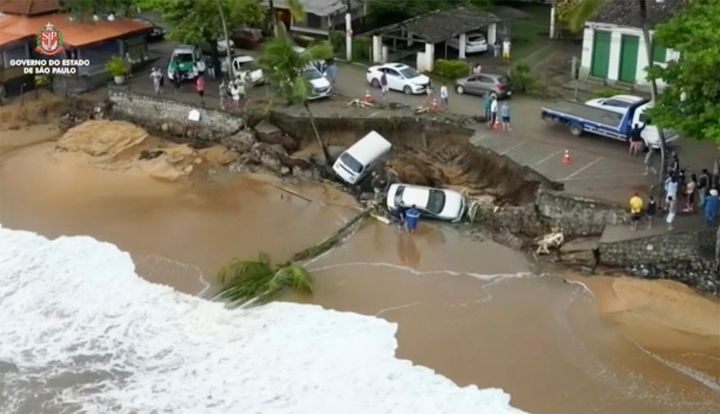 This photo provided by the Sao Paulo Government shows vehicles fallen from an elevated area along the beach in Sao Sebastiao, east of Sao Paulo, Brazil, Sunday, Feb. 19, 2023, after it was damaged by a severe weather system went through the area. 