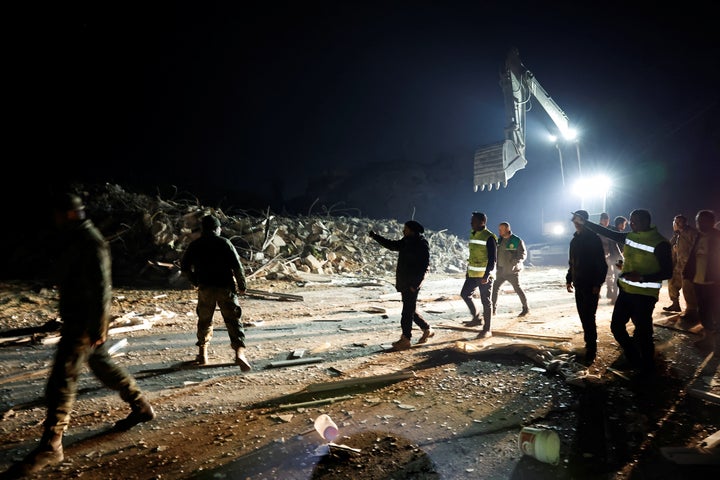 Aνθρωποι περπατούν έξω δίπλα σε ένα κτίριο που κατέρρευσε μετά από σεισμό στην Aντάκια στην επαρχία Χατάι, Τουρκία, 20 Φεβρουαρίου 2023.