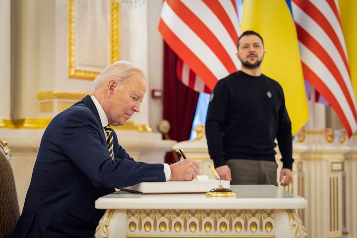 Ukrainian President Volodymyr Zelenskyy looks on as U.S. President Joe Biden signs a guest book at the Mariinsky Palace during their meeting in Kyiv, Ukraine.