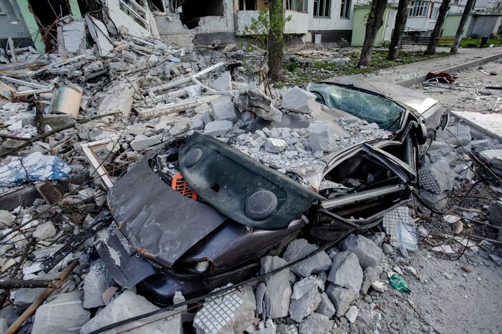 A car is crushed by rubble of a hit by shelling residential building on April 28, 2022 in Kharkiv, Ukraine. 