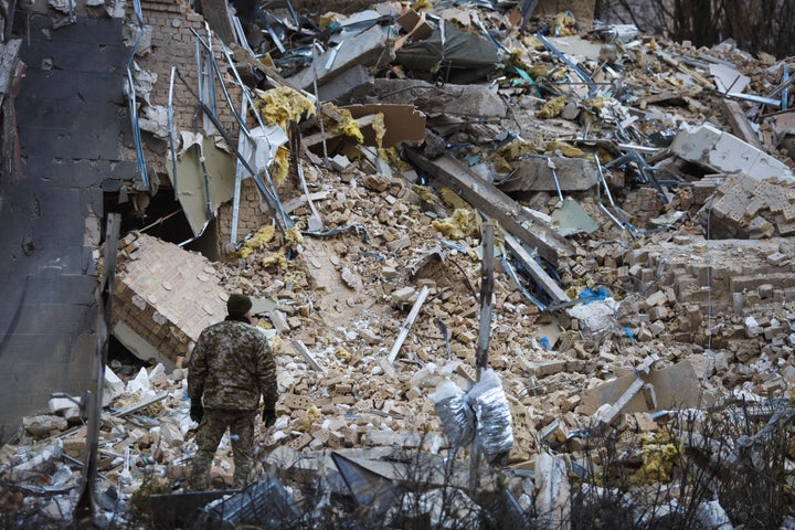 A Ukrainian soldier looks at the "Alfavito" hotel, partially destroyed by a missile strike on January 3, 2023 in Kyiv, Ukraine.