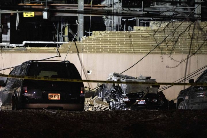 A car is seen crushed under debris outside of the plant. It was not immediately known what caused the explosion.