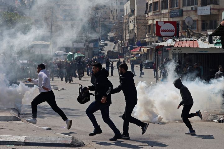 Palestinians run from teargas fired by Israeli forces amid a raid in the occupied West Bank city of Nablus, on February 22, 2023. (Photo by Zain Jaafar / AFP) (Photo by ZAIN JAAFAR/AFP via Getty Images)