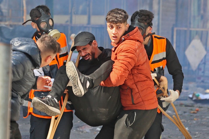 Palestinians carry away a wounded man during an Israeli raid in the occupied West Bank city of Nablus, on February 22, 2023. (Photo by Zain Jaafar / AFP) (Photo by ZAIN JAAFAR/AFP via Getty Images)