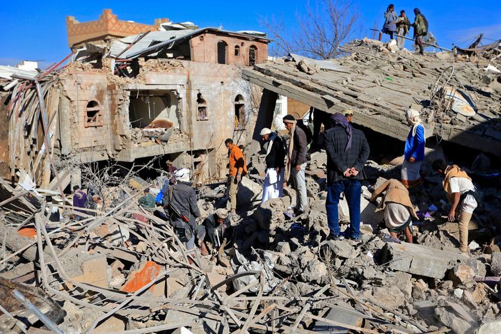 Yemenis inspect the damage following overnight air strikes by the Saudi-led coalition targeting the Huthi rebel-held capital Sanaa, on Jan. 18, 2022.