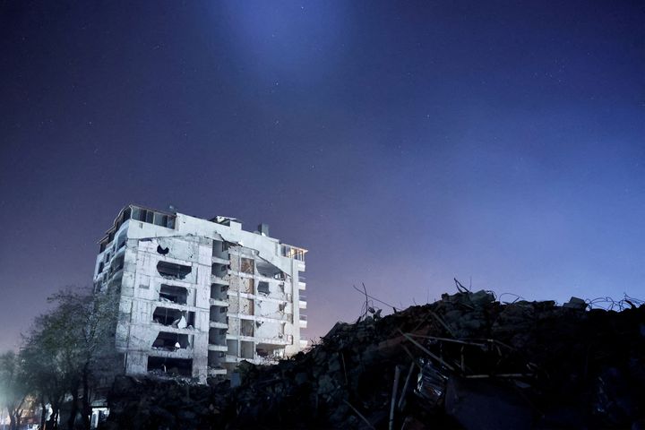 A destroyed building is seen at night, in the aftermath of a deadly earthquake, in Antakya, Hatay province, Turkey, February 21 2023. REUTERS/Clodagh Kilcoyne