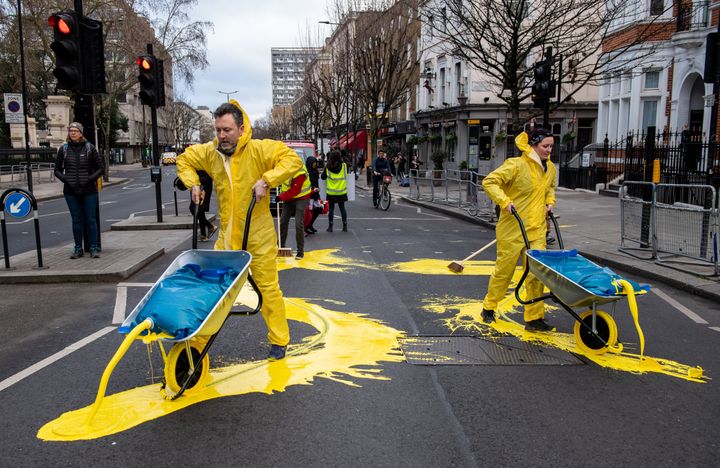 Activists from political campaign group Led By Donkeys, pour paint onto the road to create a giant Ukrainian flag outside the Russian Embassy