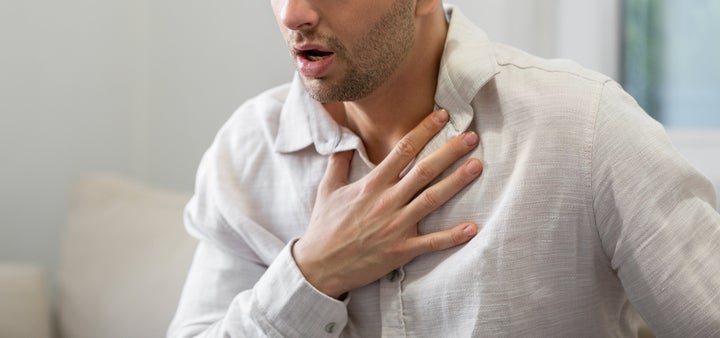 Man holding his chest in discomfort, suffering from chest pain