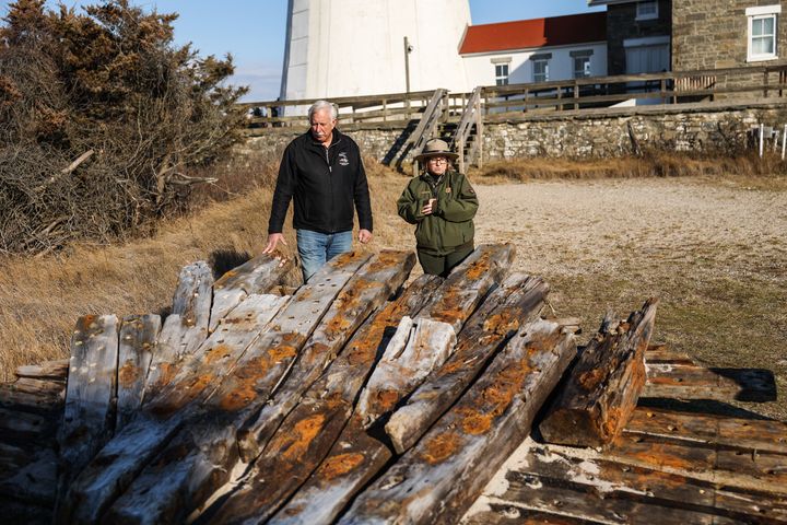 Tony Femminella, executive director of the Fire Island Lighthouse Preservation Society, and Betsy DeMaria, museum technician with Fire Island National Seashore, stand next to a section of the hull of a ship believed to be the SS Savannah which wrecked in 1821 off Fire Island.