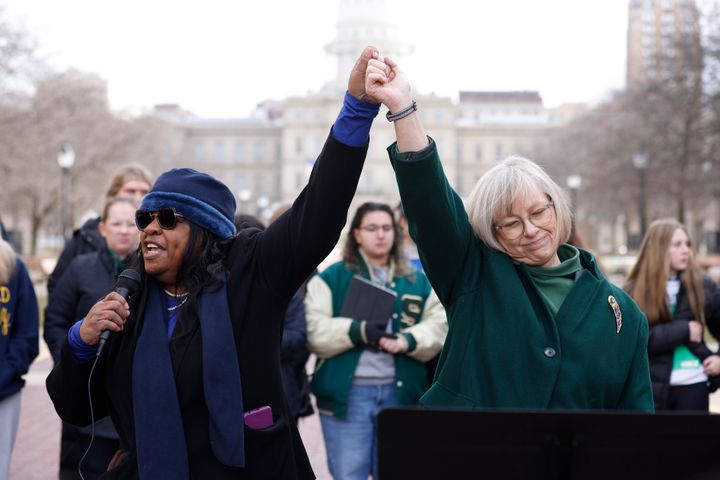 La représentante de l'État du Michigan Brenda Carter et la sénatrice de l'État Rosemary Bayer se donnent la main lors d'une conférence de presse pour appeler à une réforme des armes à feu le 20 février 2023 à Lansing, Michigan. 
