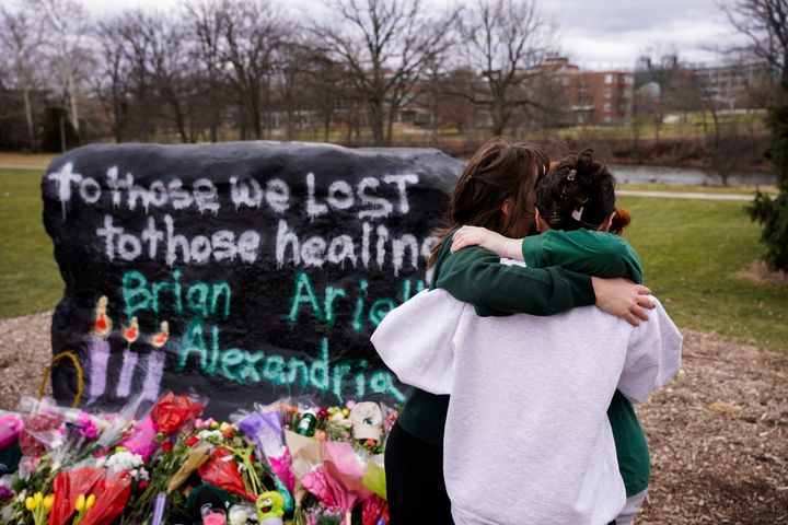 Students support each other at a memorial for the shooting victims at Michigan State University in East Lansing, Michigan.