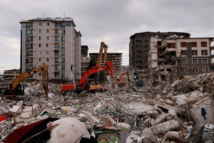 Εργαζόμενοι καθαρίζουν τα ερείπια ενός κτιρίου που κατέρρευσε μετά από θανατηφόρο σεισμό στην Aντιόχεια, επαρχία Χατάι, Τουρκία, 21 Φεβρουαρίου 2023.