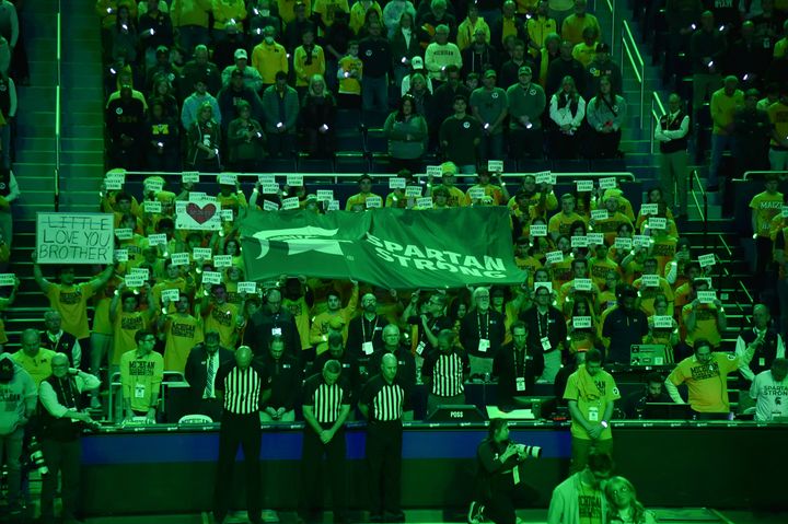 The University of Michigan student section raises the "Spartan Strong" flag prior to a game on Feb. 18, 2023, to support rival Michigan State after a deadly shooting there. 