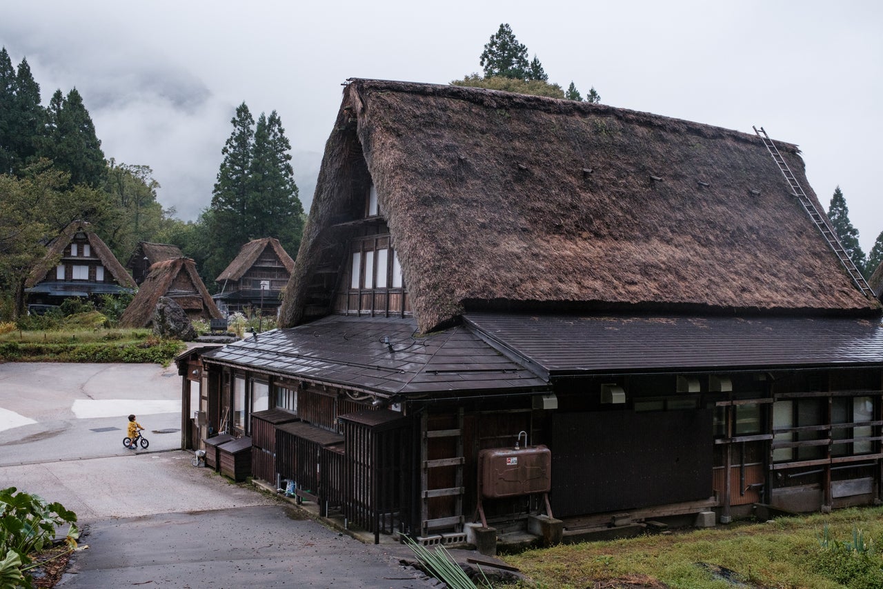 A boy on his bicycle in the village of Ainokura, Gokayama. The area is a UNESCO World Heritage Site due to its traditional thatched-roof farmhouses.