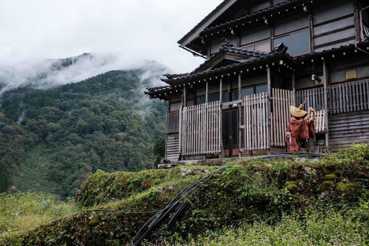 A Kokiriko dancer performs a traditional dance native to this region in front of a house in Ainokura, Gokayama.