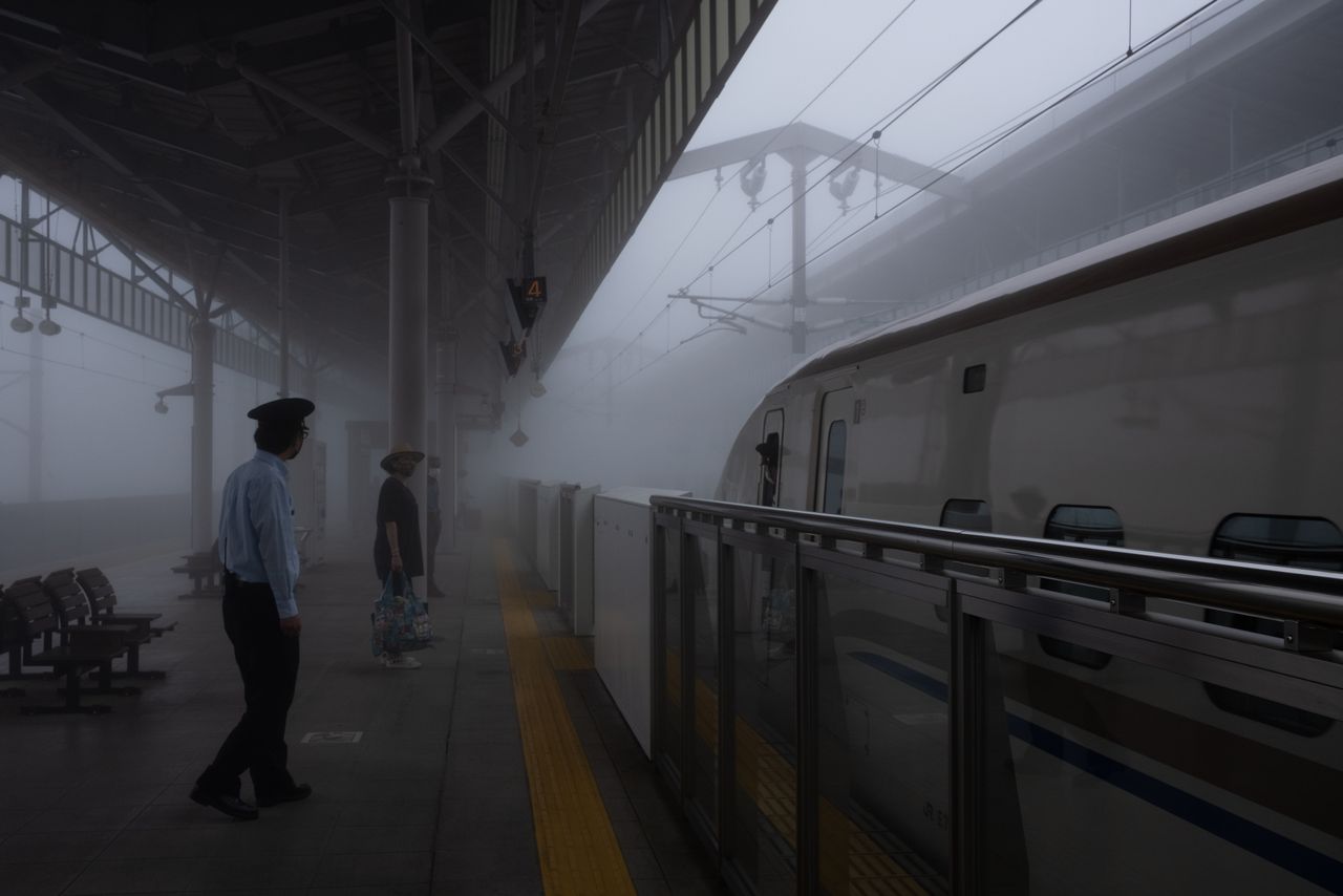 A bullet train arrives in the fog at Karuizawa Station.