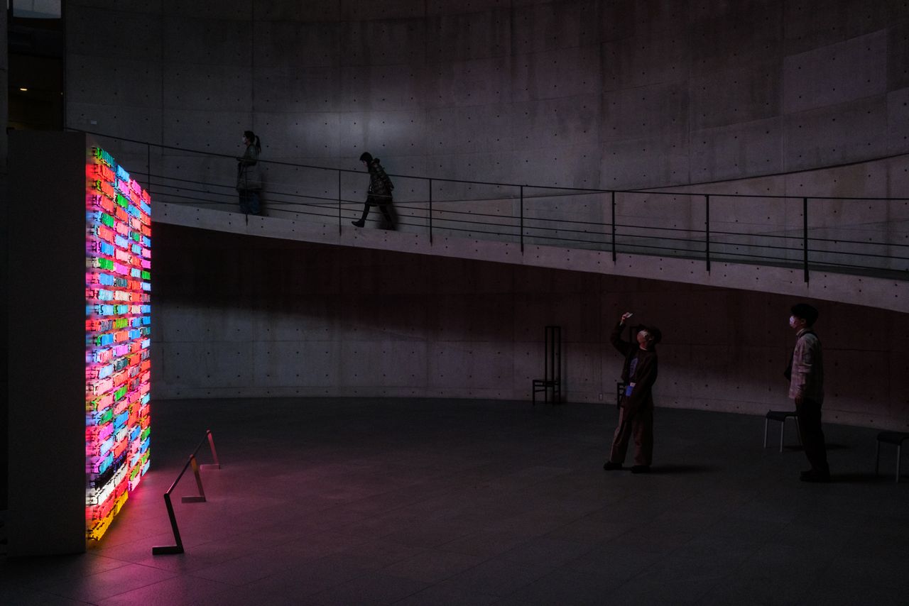 Museum visitors walk by Bruce Nauman's "100 Live and Die" at Benesse House Museum in Naoshima. (©Bruce Nauman)