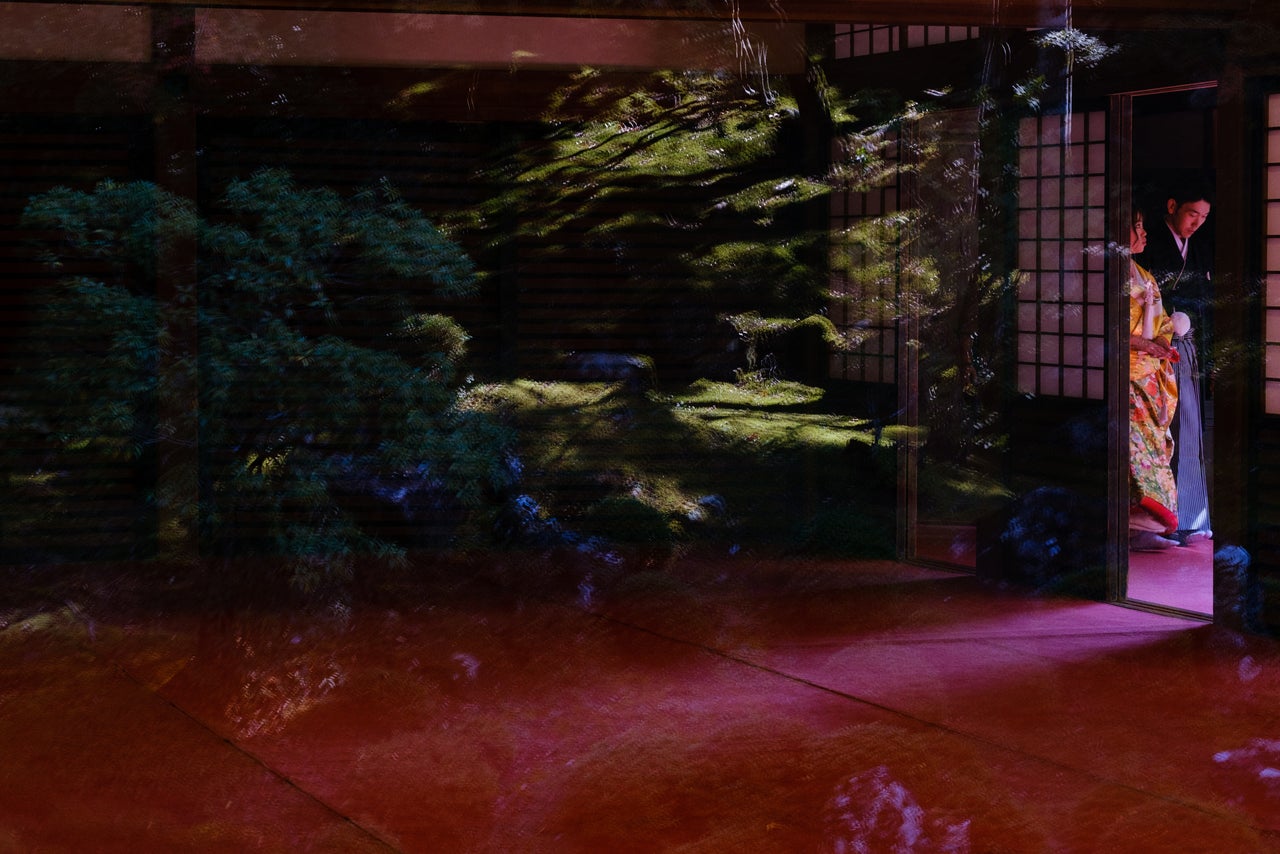 A couple poses for their wedding photographs at a temple garden in Shikoku.