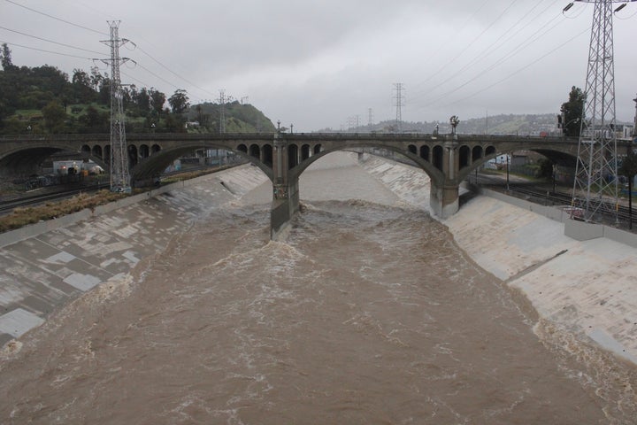 The rain-swollen Los Angeles River flows near downtown Los Angeles.