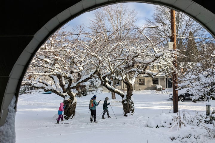 People make their way through a snow-covered street in the Grant Park neighborhood of Portland, Ore., Thursday Feb. 23, 2023. The city experienced its second snowiest day on record. (AP Photo/Drew Callister)