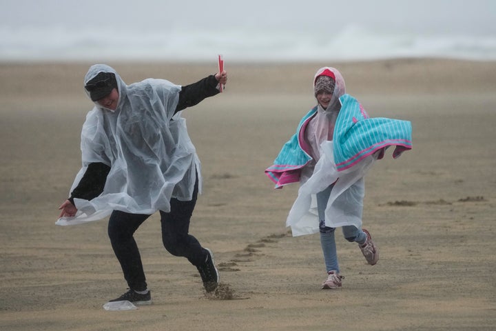 Beach combers run along the sand at Huntington Beach, California.