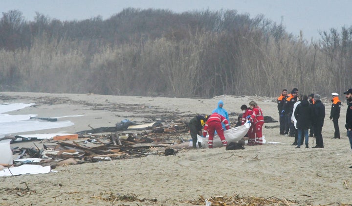 Rescuers are seen handling a body bag at the site of the shipwreck in Steccato di Cutro, south of Crotone.