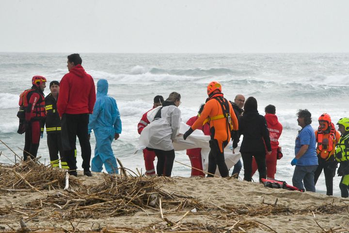 Rescuers are seen recovering a body at a beach near Cutro, southern Italy, on Sunday.