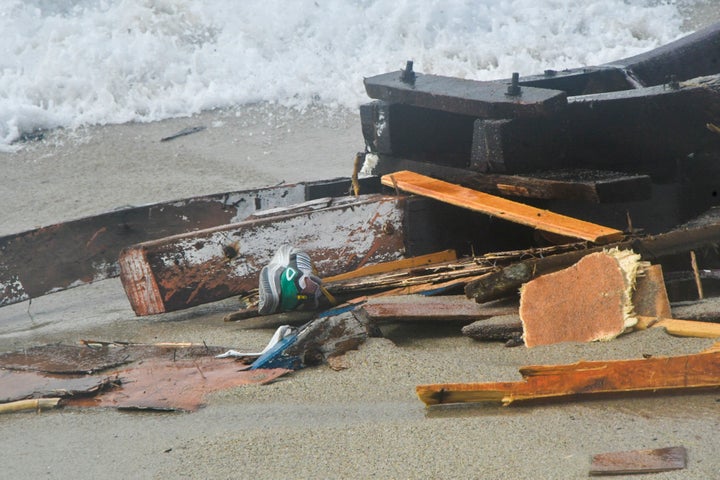 The wreckage from a capsized boat washes ashore at a beach near Cutro, southern Italy, on Sunday.