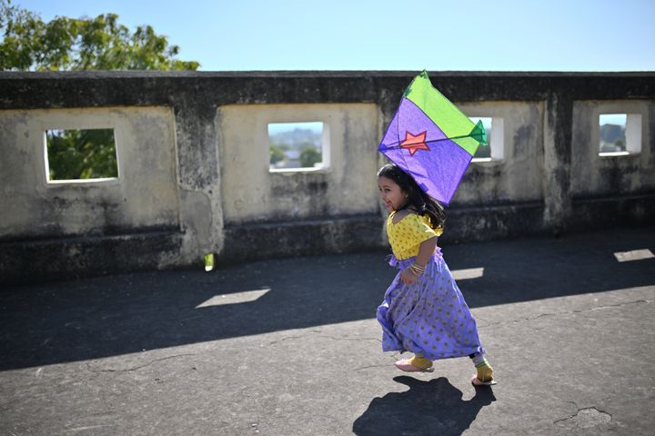 Στιγμιότυπο από το Makar Sankranti, το ινδουιστικό φεστιβάλ αφιερωμένο στη θεότητα του ήλιου και σηματοδοτεί μια νέα αρχή. Εικονίζεται κορίτσι που τρέχει με χαρταετό στη βεράντα ενός παλατιού στο Ρατζαστάν.<br><br> Indian Hindu festival dedicated to solar deity and is observed to mark new beginning, Cute girl running with a kite on the terrace of a Palace in Rajasthan