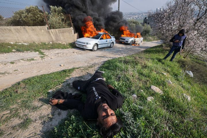 A Palestinian youth lies injured during clashes with Israeli settlers from the nearby Bracha settlement, who reportedly set fire to cars in Burin village in the occupied West Bank on February 25, 2023.
