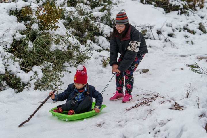 Aaron Lee, 7, and his mother play in the snow at the Deukmejian Wilderness Park, a rugged 709-acre site in the foothills of the San Gabriel Mountains, at the northernmost extremity of the City of Glendale, Calif., on Feb. 26, 2023. 