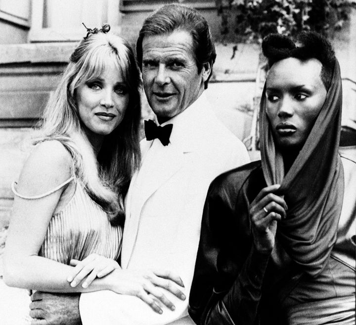 Ο Ρότζερ Μουρ - Τζέιμς Μποντ με τις συμπρωταγωνίστριες του Τάνια Ρόμπερτς και Γκρέις Τζόουνς, στα γυρίσματα της ταινίας «A View To Kill» (Τζέιμς Μποντ: Επιχείρηση Κινούμενος Στόχος) κοντά στο Παρίσι, 17 Αυγούστου 1984. (AP Photo/Alexis Duclos)