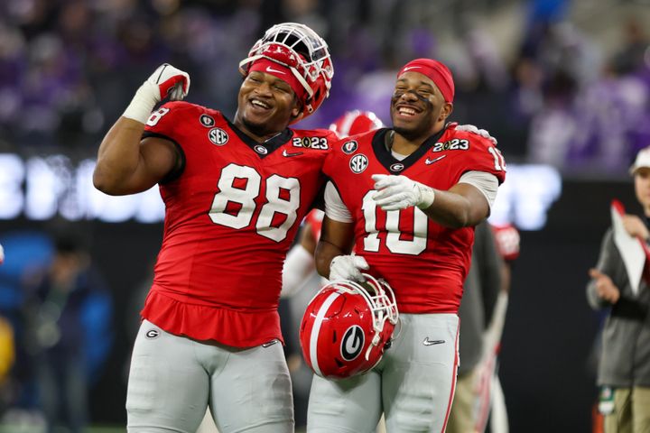 Georgia Bulldogs defensive lineman Jalen Carter (88), pictured with linebacker Jamon Dumas-Johnson during the Bulldogs' national champship game victory over TCU, was preparing to turn himself in, police say.