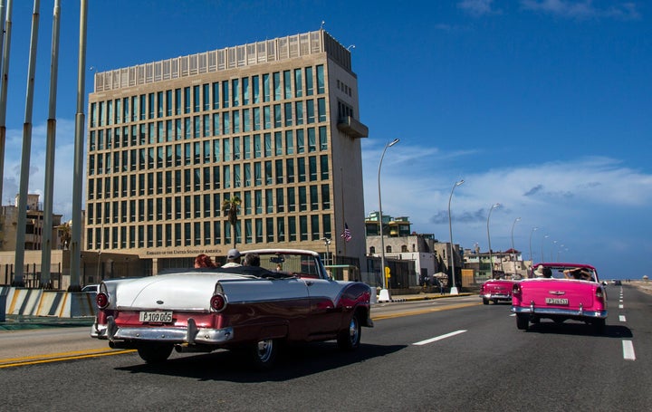 FILE - Tourists ride classic convertible cars on the Malecon beside the U.S. Embassy in Havana, Cuba, on Oct. 3, 2017. The State Department is preparing to compensate victims of mysterious brain injuries colloquially known as “Havana Syndrome” with six-figure payments, according to officials and a congressional aide. Current and former State Department staff and their families who suffered from “qualifying injuries” since cases were first reported among U.S. embassy personnel in Cuba in 2016 will receive payments of between roughly $100,000 and $200,000 each, the officials and aide said. (AP Photo/Desmond Boylan, File)