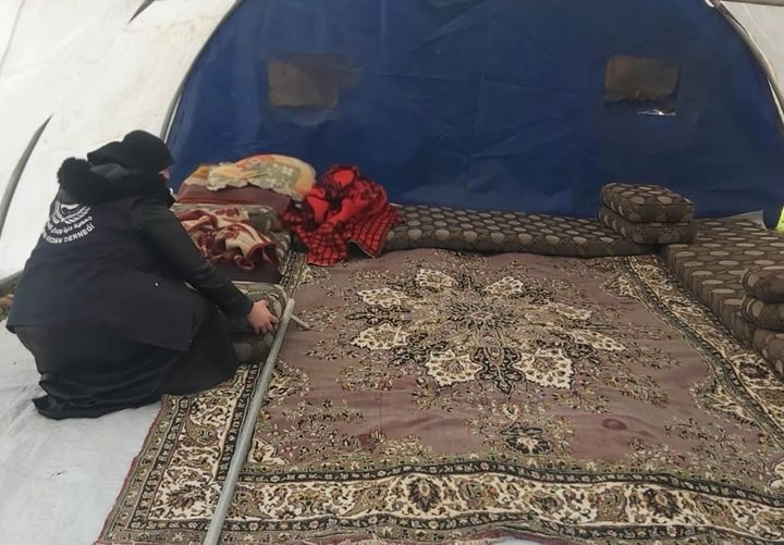 Shaza Hamo preparing a tent for a Syrian woman after the February earthquakes.