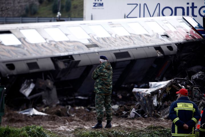 Ένας αξιωματικός και ένας πυροσβέστης στέκονται κοντά στα συντρίμμια των τρένων, μετά το σιδηροδρομικό δυστύχημα της Τρίτης, το πιο θανατηφόρο που έχει καταγραφεί στη χώρα, στα Τέμπη, περίπου 376 χιλιόμετρα (235 μίλια) βόρεια της Αθήνας, κοντά στη Λάρισα, Ελλάδα, Παρασκευή 3 Μαρτίου, 2023. Η Ελλάδα έχει περιορισμένο σιδηροδρομικό δίκτυο που δεν φτάνει σε μεγάλο μέρος της χώρας. Παρά τα χρόνια έργων εκσυγχρονισμού, μεγάλο μέρος των βασικών εργασιών ελέγχου σιδηροτροχιών εξακολουθεί να λειτουργεί με το χέρι. (AP Photo/Giannis Papanikos)