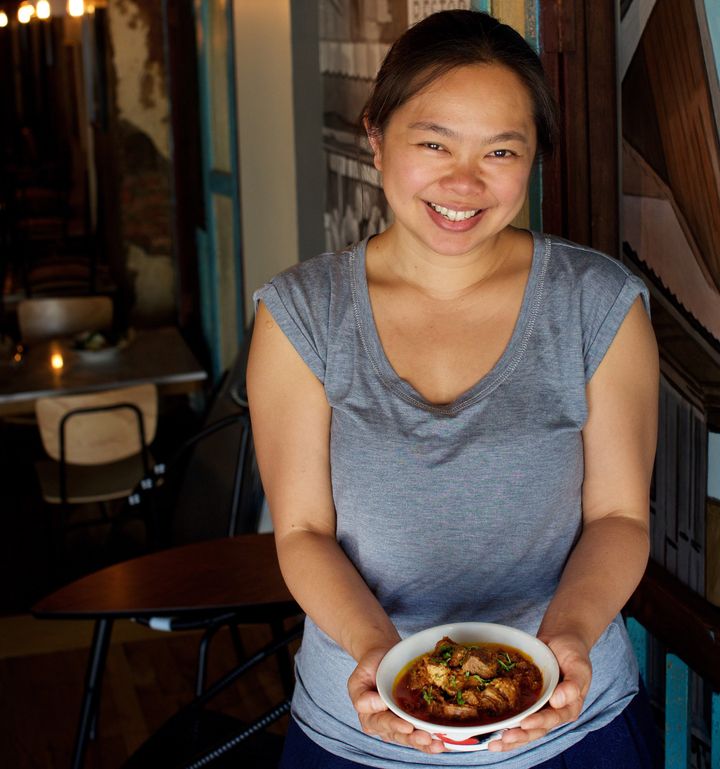 Ange Branca holds a bowl of rendang daging (braised beef in a paste of mixed spices and coconut cream slow cooked for six hours) at Saté Kampar in Philadelphia.