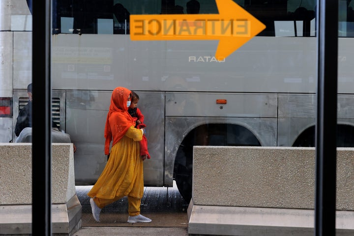 Refugees board buses that will take them to a processing center after they arrive at Dulles International Airport after being evacuated from Kabul following the Taliban takeover of Afghanistan Aug. 27, 2021, in Dulles, Virginia.