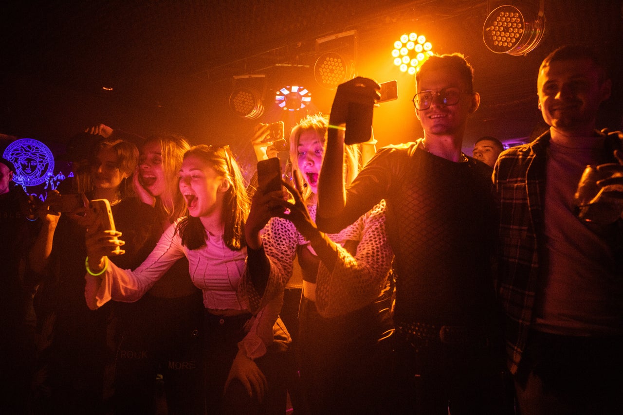 The audience takes photos during the drag show.