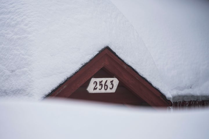 Snow is piled up on a home in Running Springs, California, Tuesday, Feb. 28, 2023. 