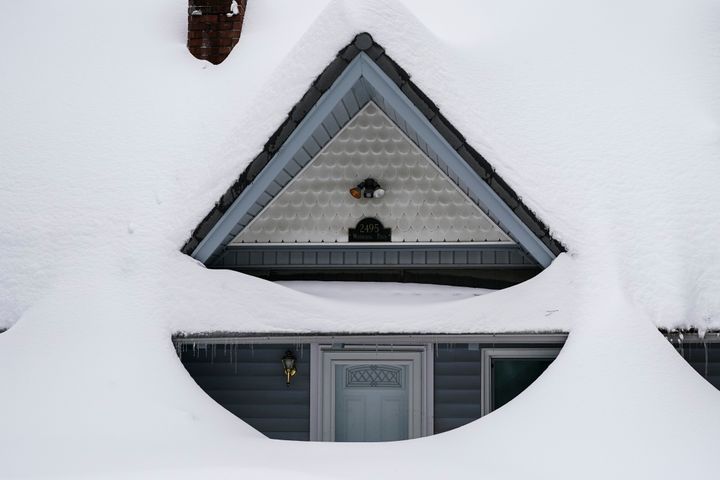 Snow is piled up on a home in Running Springs, California, Tuesday, Feb. 28, 2023. 