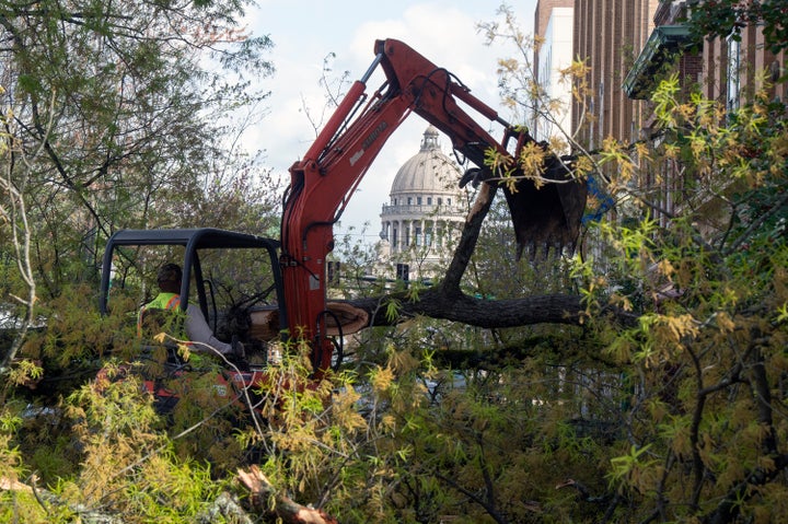 The Mississippi Capitol dome serves as a backdrop as city of Jackson, Mississippi, employees clear a tree fallen from the property surrounding the governor's mansion Friday, March 3, 2023. 