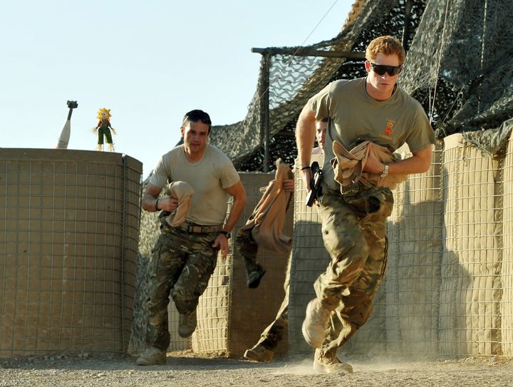 Prince Harry, right, races out from a tent with his fellow pilots at Camp Bastion on Nov. 3, 2012, in Afghanistan.