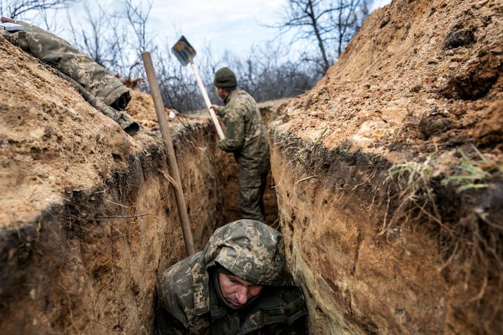 A Ukrainian infantryman with the 28th Brigade takes cover in a partially dug trench along the frontline facing Russian troops 250 metres away.
