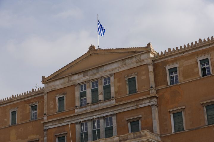 A Greek flag flutters atop the parliament building in Athens, Greece, March 1, 2023. REUTERS/Louiza Vradi