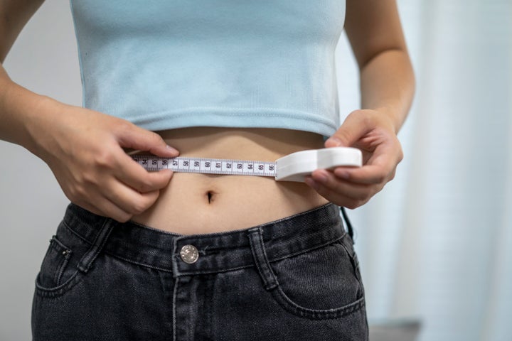 A young woman was measuring her waist