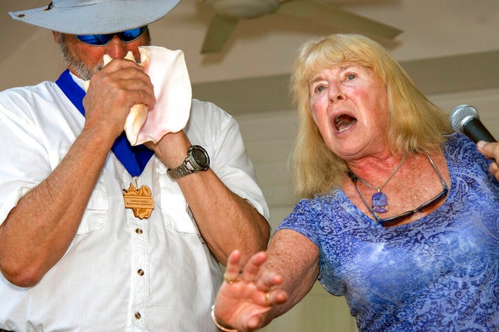 In this photo provided by the Florida Keys News Bureau, Michael Wachter, left, and Georgann Wachter perform during the Conch Shell Blowing Contest, Saturday, March 4, 2023, in Key West, Fla. The couple won the contest's group division by parodying Elvis Presley's "Hound Dog" in an offbeat duet for voice and conch shell. Organized by the Old Island Restoration Foundation, the contest is a Key West tradition that began in 1972. The conch shell is a symbol of the Florida Keys. (Mary Martin/Florida Keys News Bureau via AP)